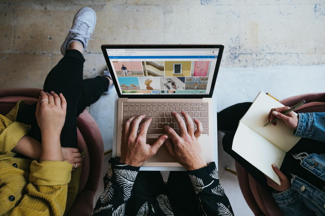 3 people gathering around a laptop