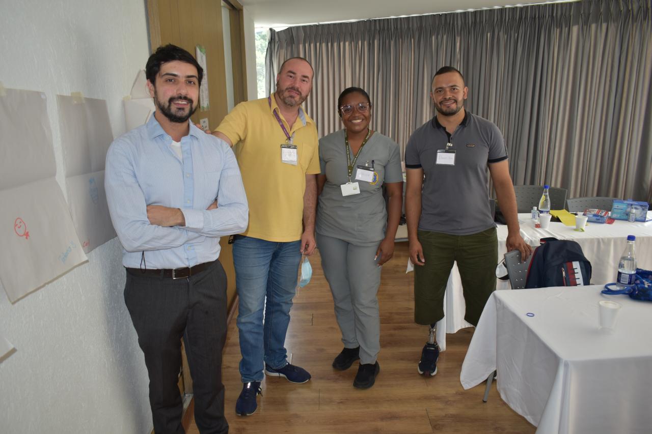 Group of four people standing in room after during Polus' Model Coherency human service program design workshop in Colombia.