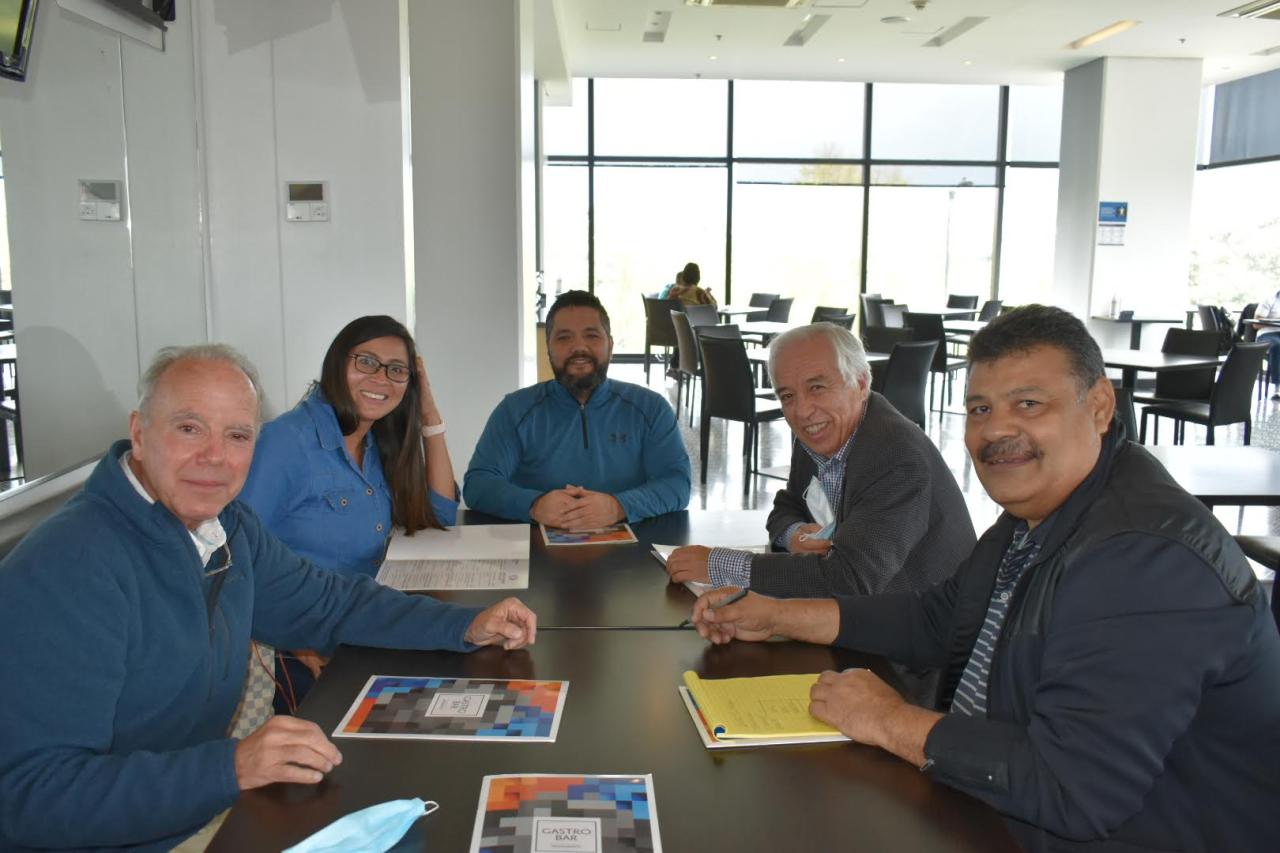 Group of people sitting at a table during one of Polus' Model Coherency human service program design workshop in Colombia.
