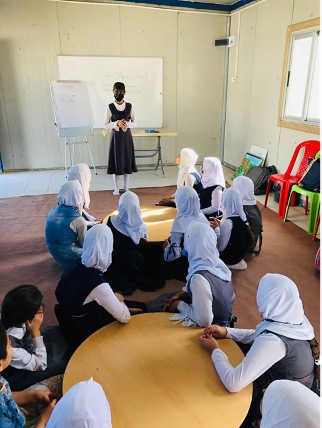 Teacher in front of classroom of young girls in Mosul, Iraq