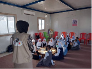 Teacher in front of classroom of young girls in Mosul Iraq