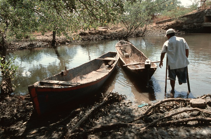 Man with prosthetic leg standing in river pulling in a boat (photo by Stephen Petegorsky)