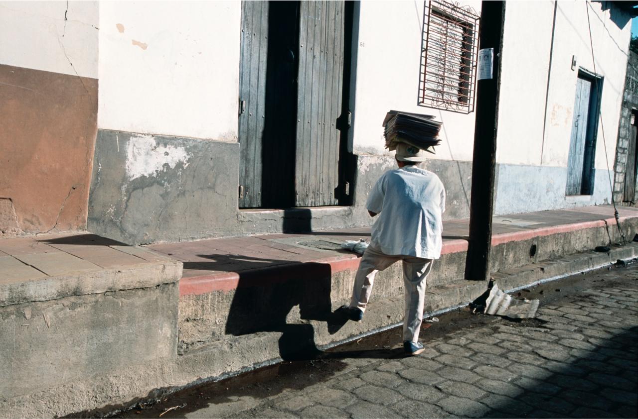 Man walking up steep steps in Leon, Nicaragua carrying newspapers on his head. (photo by Stephen Petegorsky)
