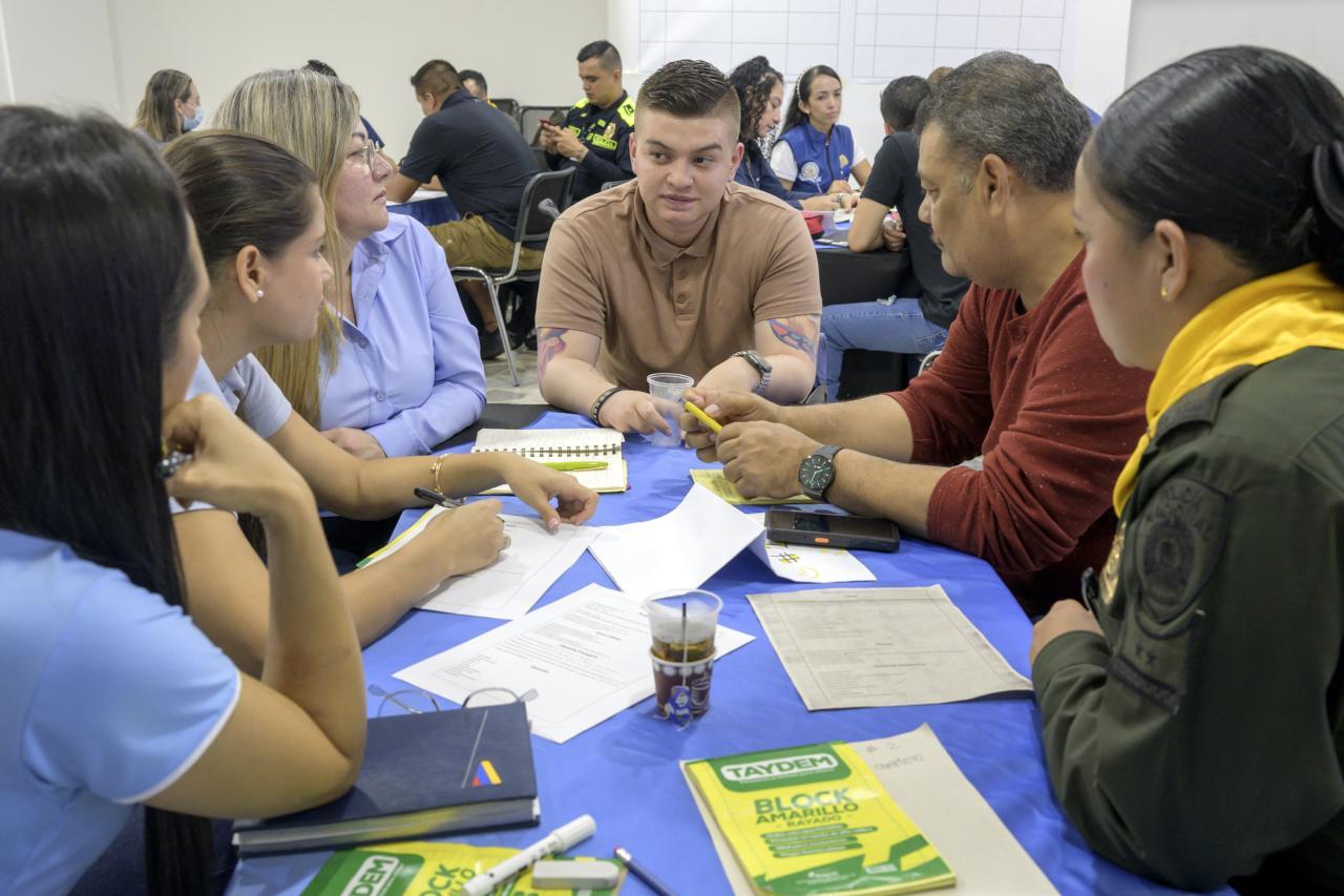 Man sitting at table with five other people facing him. They are participants in one the Polus Center's Model Coherency human service design workshops.
