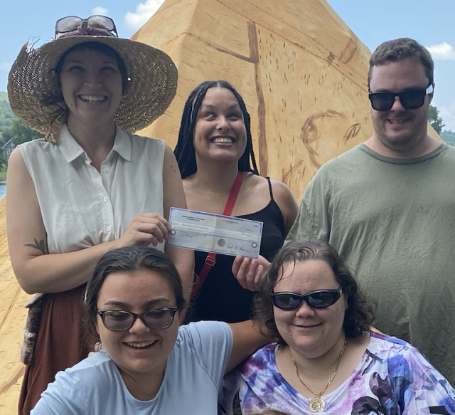 Polus staff pose with Precious Perez holding the grant check