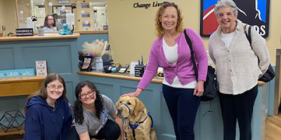 Staff and students with dog in a service vest